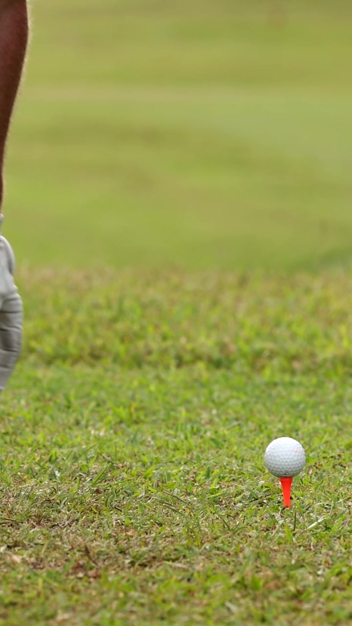 Golfista che posiziona attentamente la palla sul tee