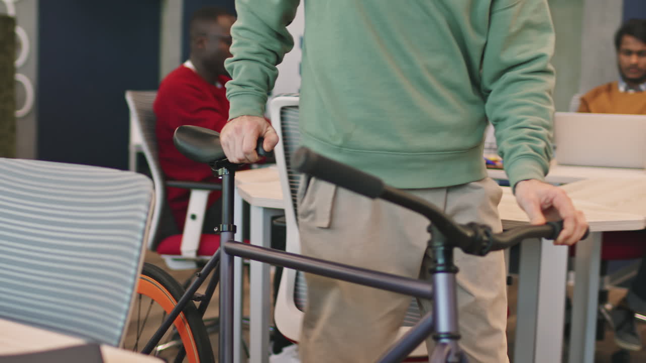 Unrecognizable Man with Bicycle Walking into Office