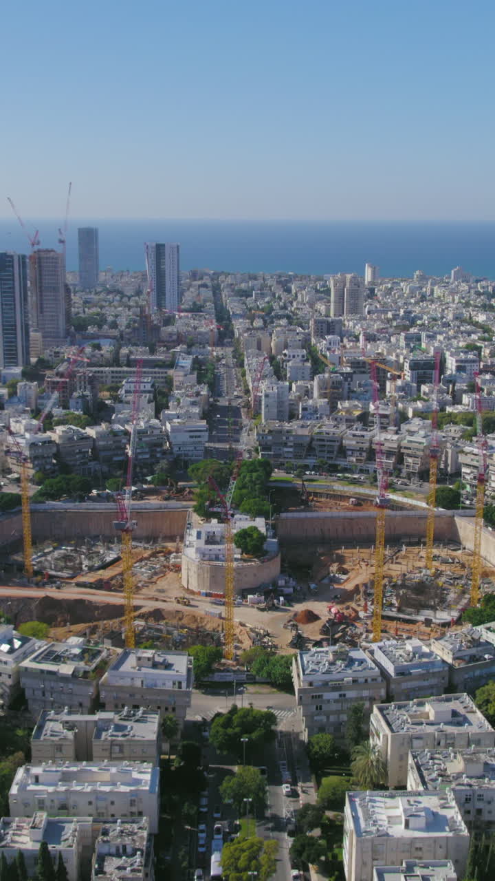 Vertical aerial push in shot to impressive project construction - Tel Aviv beaches in the background