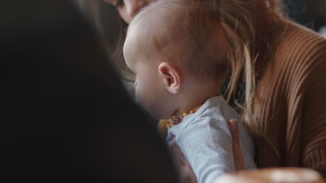 young mother caring for baby in cafe nurturing child relaxing in busy restaurant enjoying motherhood