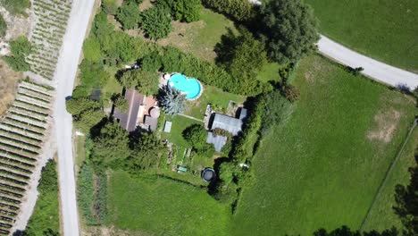 Beautiful-cottage-with-swimming-pool-near-a-green-forest,-drone-aerial-4k-video