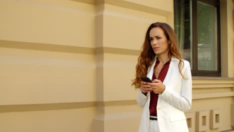Focused-businesswoman-texting-on-smartphone