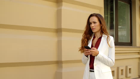 focused businesswoman texting on smartphone