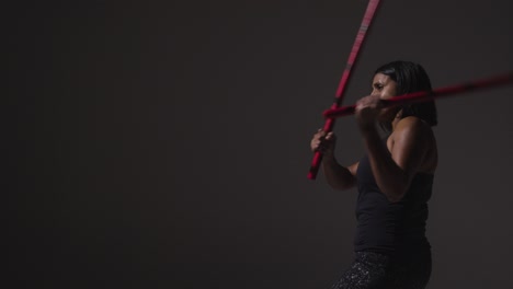 Studio-Shot-Of-Mature-Woman-Wearing-Gym-Fitness-Clothing-Exercising-With-Martial-Arts-Escrima-Sticks-1