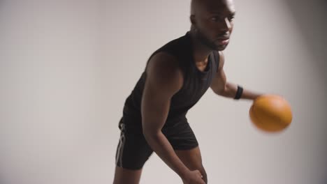Nahaufnahme-Eines-Männlichen-Basketballspielers,-Der-Den-Ball-Vor-Weißem-Hintergrund-Dribbelt-Und-Hüpft-2