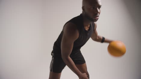 Close-Up-Studio-Shot-Of-Male-Basketball-Player-Dribbling-And-Bouncing-Ball-Against-White-Background-2