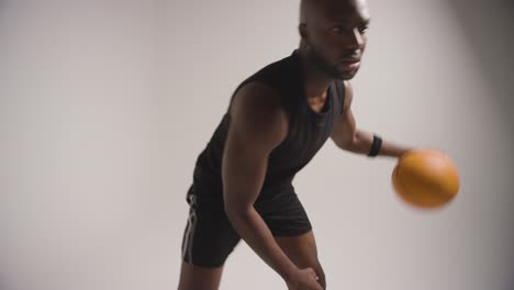 disparo de estudio de cerca de un jugador de baloncesto masculino driblando y rebotando la pelota contra un fondo blanco 2