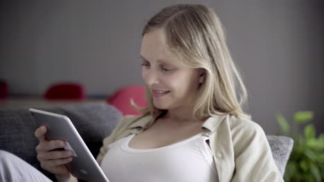 happy pregnant woman using tablet