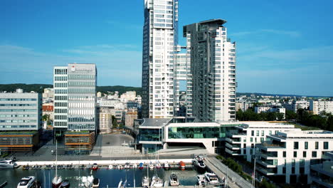 ocean view modern apartment building looks over pier and boats on blue sky day