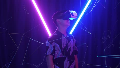 vr, futuristic, entertainment concept. excited asian boy using virtual reality headset with neon light at the background