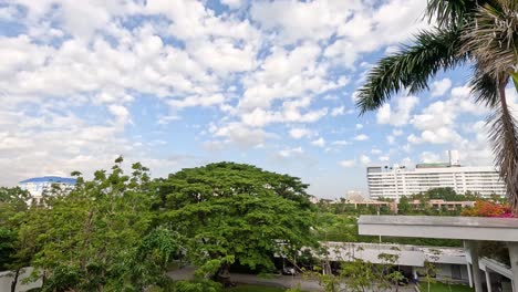 time-lapse of clouds over city buildings and foliage