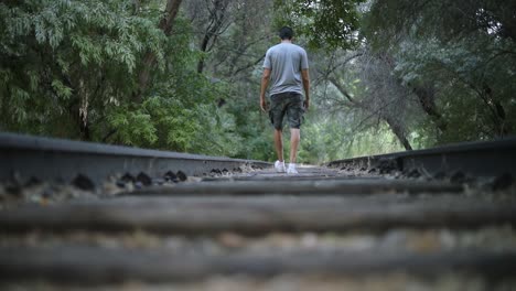 slow motion shot of a lonely person walking on abandoned train tracks