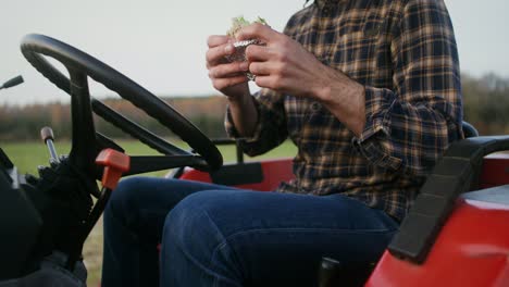 granjero comiendo almuerzo en un tractor