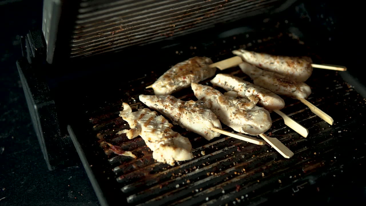 Closing the grill lid, pieces of meat lie on the grill