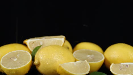 on cut and whole lemons falling drops of water.