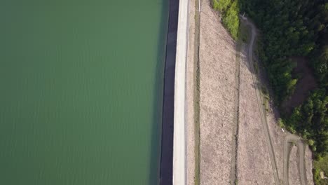 Espectáculo-Aéreo-De-Arriba-Hacia-Abajo-De-La-Carretera-Que-Divide-El-Agua-Y-El-Paisaje,-Simétrico