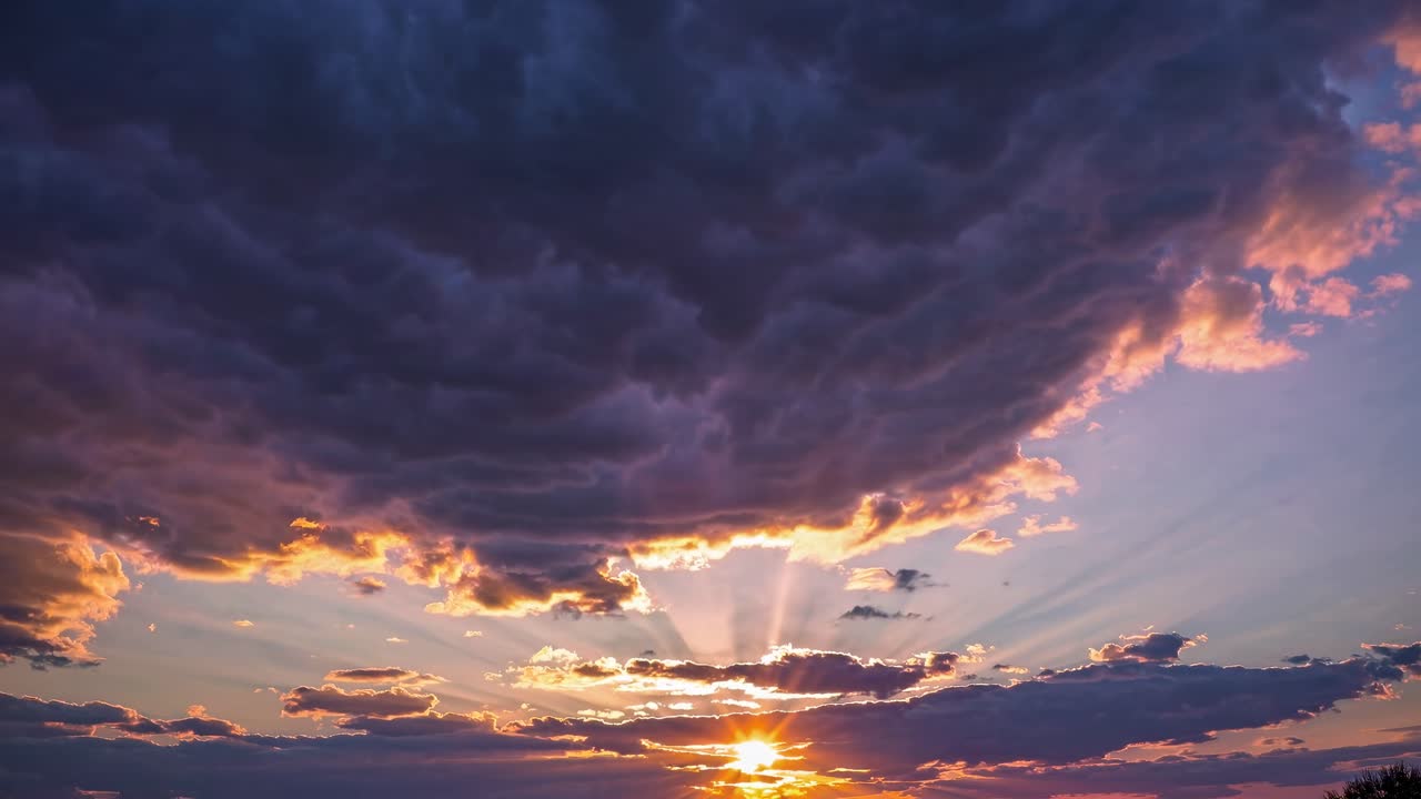 Dramatic sunset video with a low-angle view capturing vibrant colors and sun rays piercing