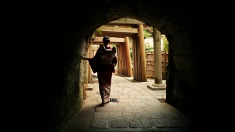 woman in kimono walking through a japanese temple