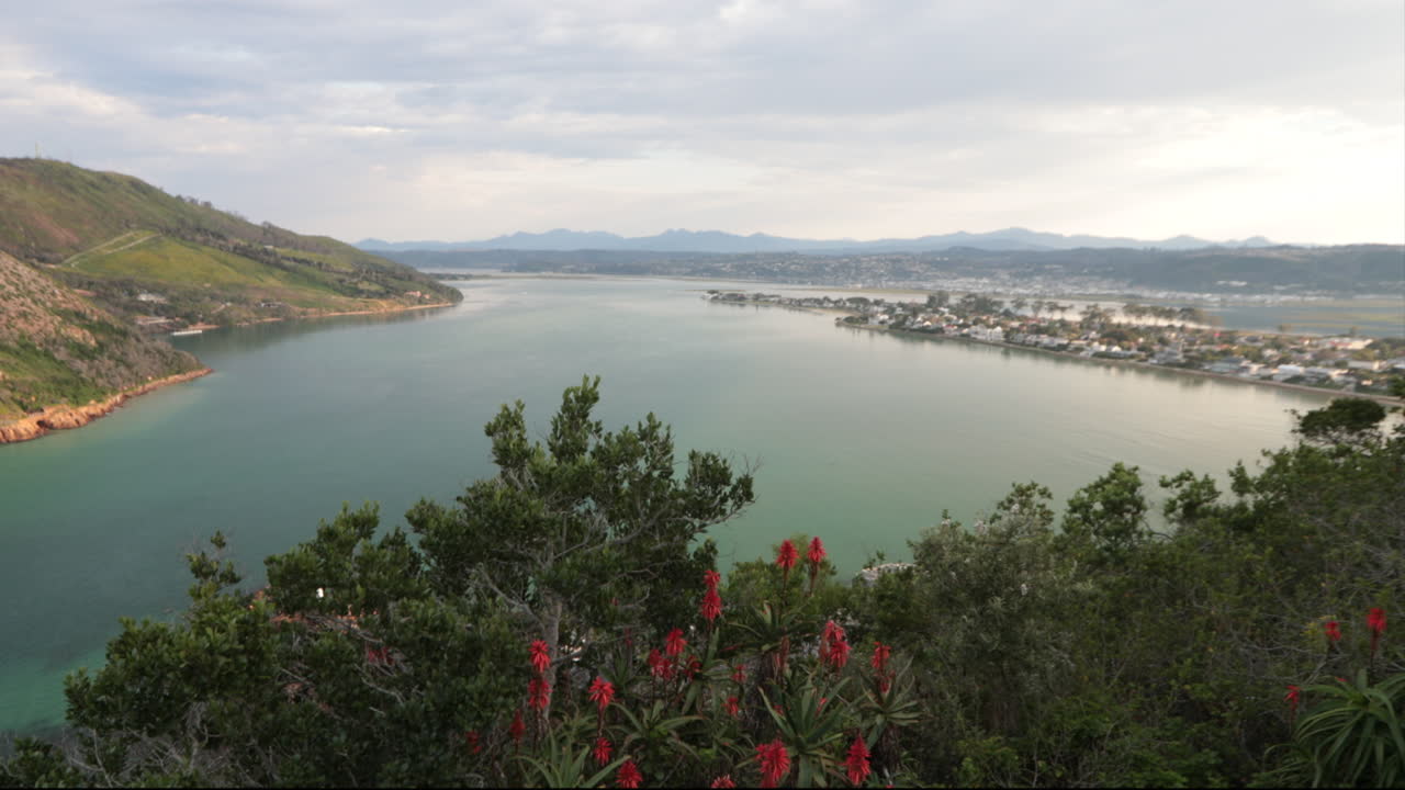 un hermoso día de verano con vistas a las cabezas de knysna desde un mirador con barcos que entran y salen del océano índico