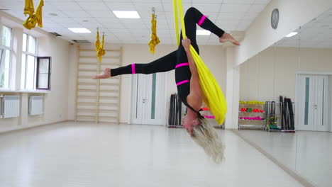 Antigravity-instructor-aerology-in-the-paintings-makes-a-revolution-through-the-head,-a-somersault-in-the-air.-Slow-motion-camera-shooting