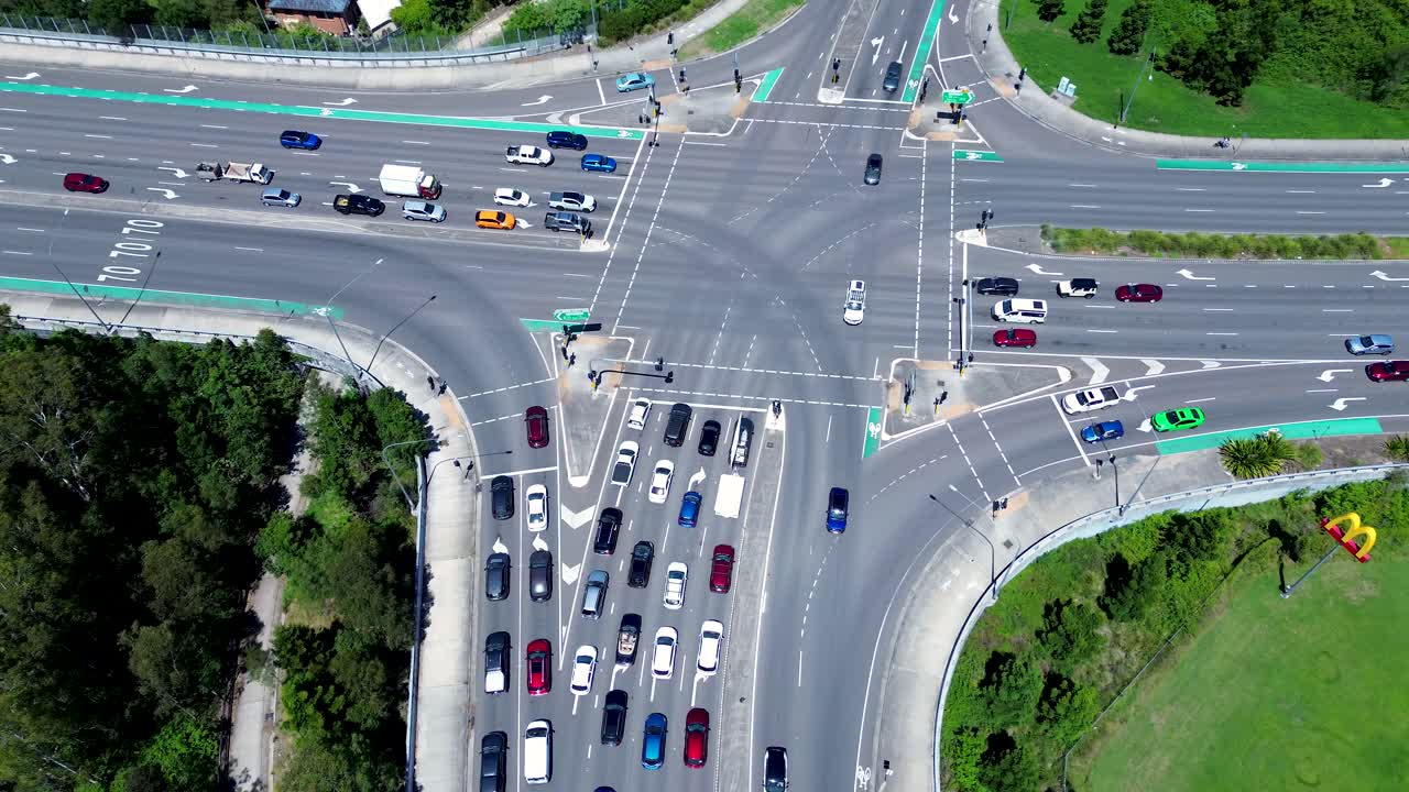 Drone aerial landscape of car vehicles driving through main road intersection bust stoplights street Tuggerah Central Coast Australia travel transport urban infrastructure traffic