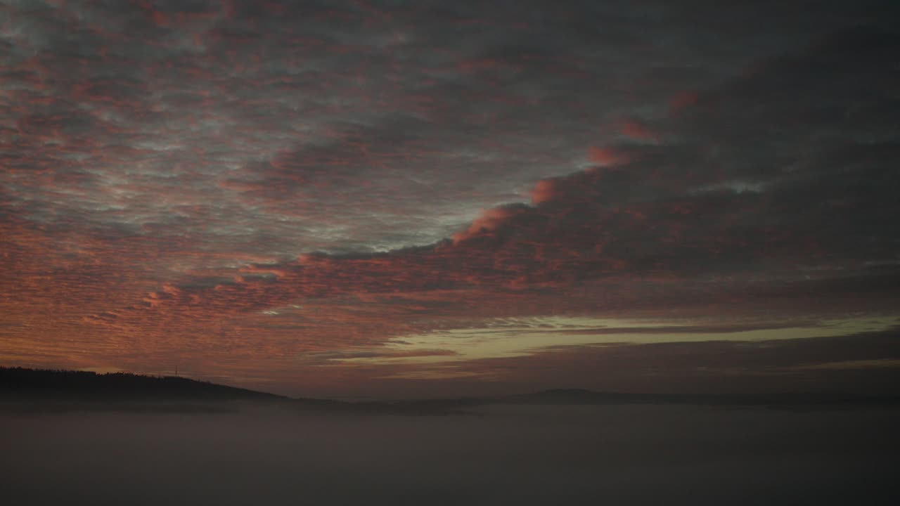 Ein Naturschauspiel: Roter und oranger Sonnenuntergang über Nebelschwaden