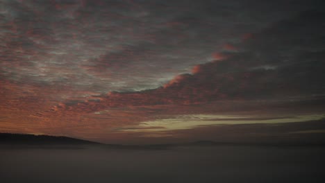 a natural spectacle: red and orange sunset over fog mist