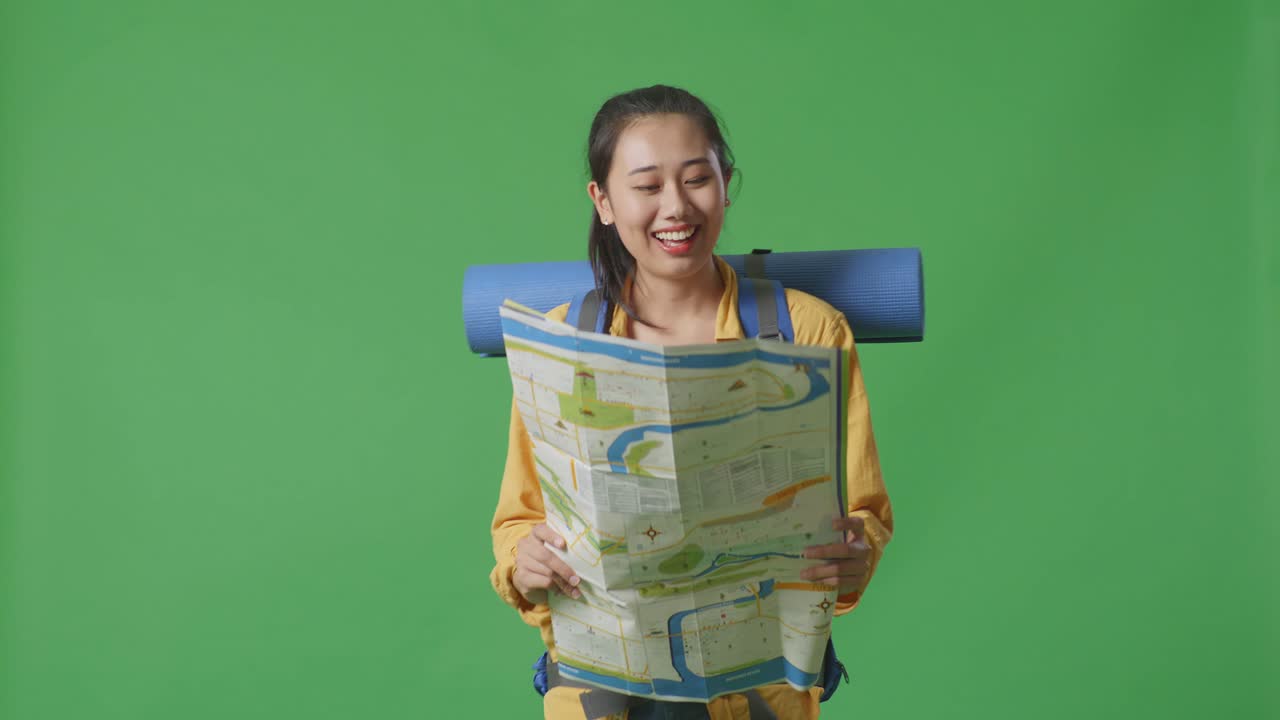 mujer leyendo un mapa con una mochila