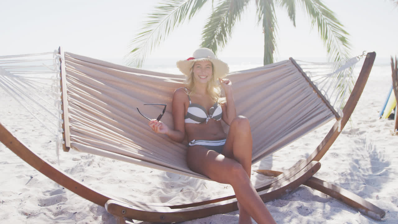 Caucasian woman lying on a hammock on the beach