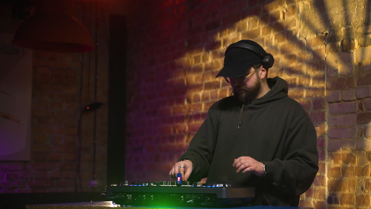 hombre con gorra negra pinchando en la discoteca.