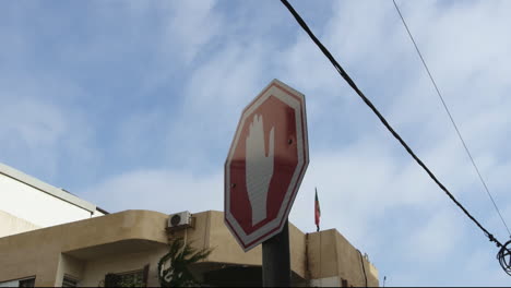 a stop sign in the middle of a street with a bright blue sky and electricity cords in the background