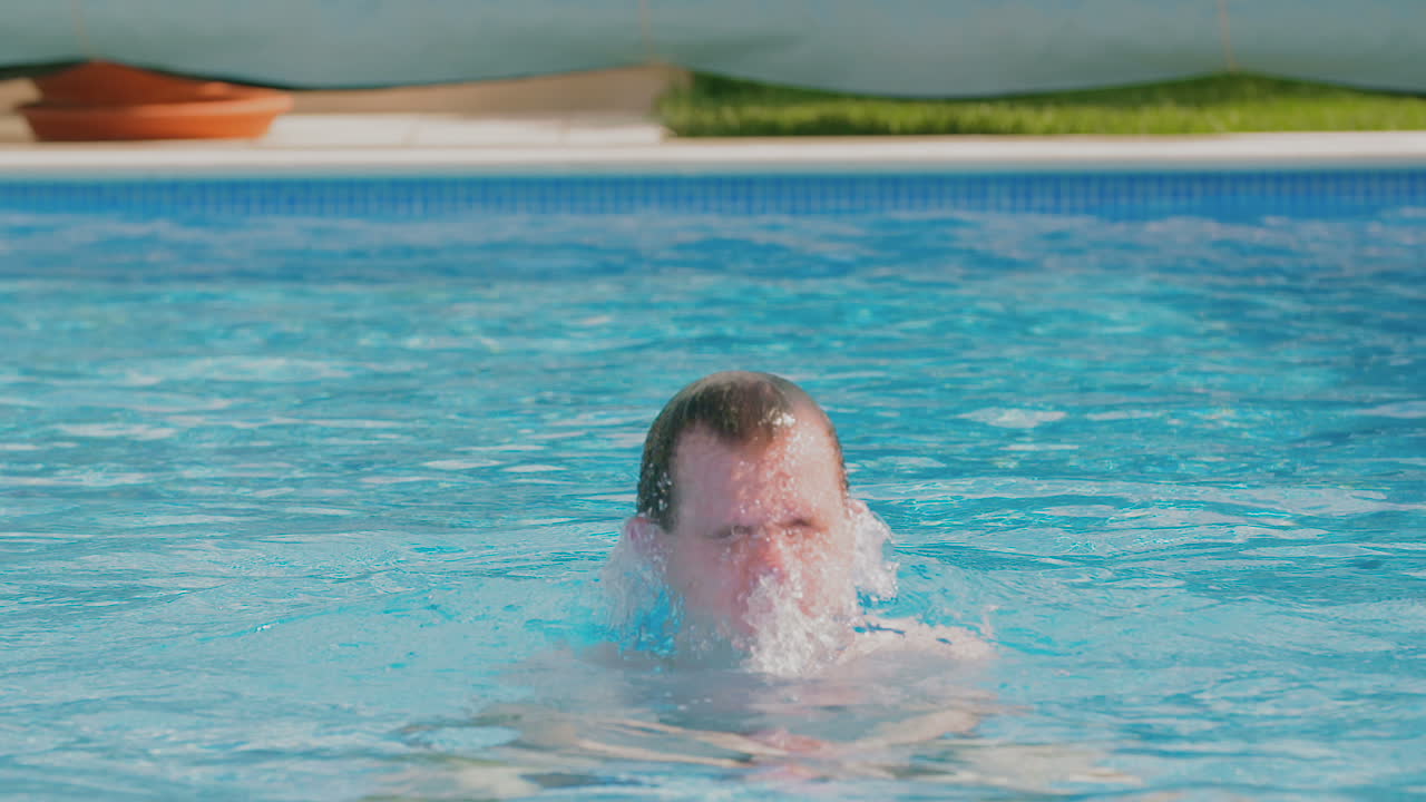 joven salpica agua en la piscina