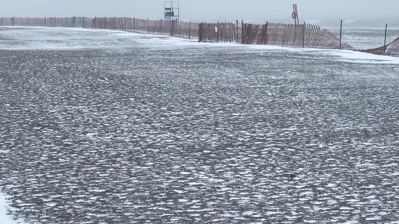 해변 근처의 얼어붙은 풍경과 함께 눈 바람과 추운 날씨