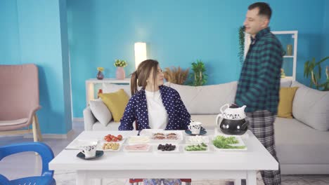 happy man and woman enjoying breakfast together at the dinner table and are very in love with each other.
