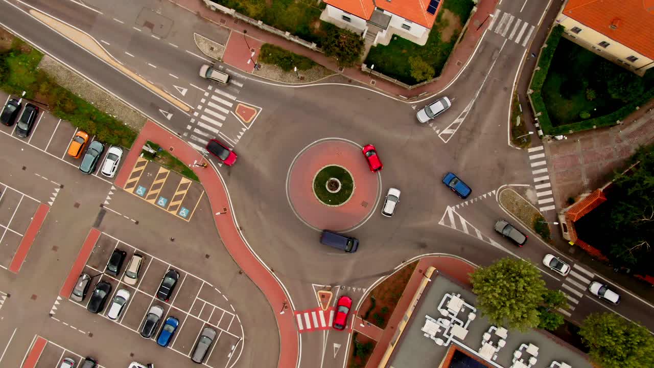 회전하는 상승하는 드론 은 순환 교차로에서 운행되는 자동차를 보여줍니다.