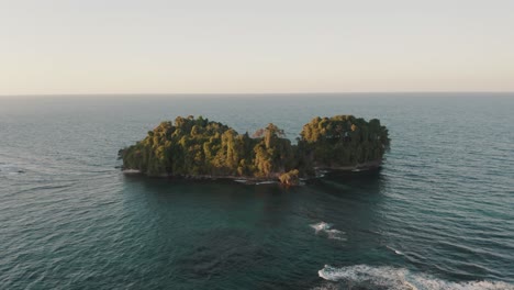 vista aérea que muestra una isla verde tropical en el mar caribe durante la puesta de sol