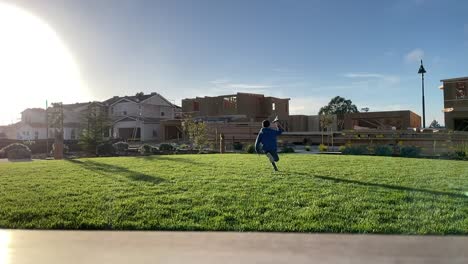 boy running on grass with paper airplane in hand