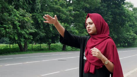 Slow-motion-of-a-young-smiling-Afghan-girl-in-a-black-and-red-dress-standing-on-the-side-of-the-road-waiting-for-public-transport-to-go-back-home