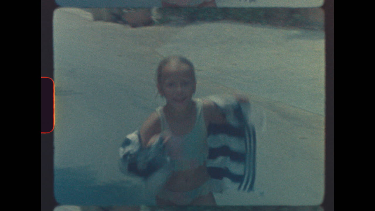 Vintage footage of a girl with a towel at the beach