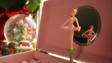 christmas magic as a ballerina slowly spins in front of a snow globe