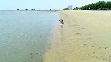 4K woman walk on the beach, foot print on sand texture and coconut tree on the beach photo by drone.