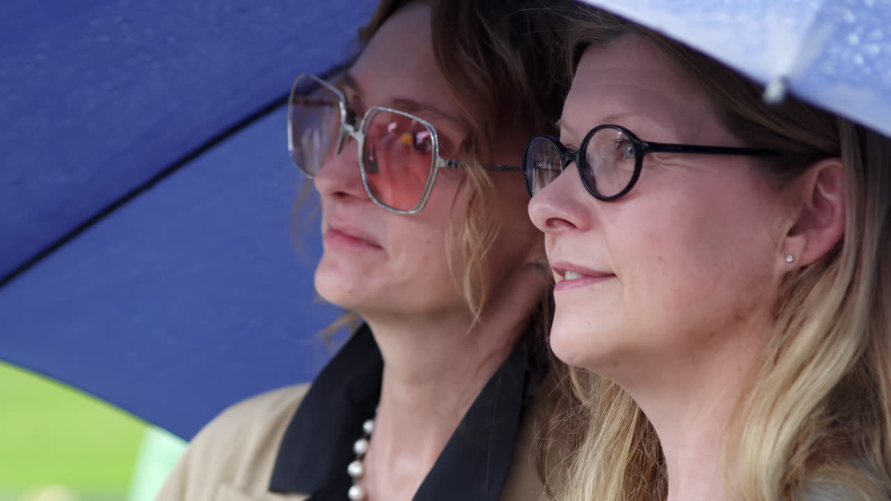 dos mujeres bajo un paraguas en la lluvia