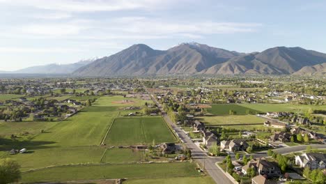 aerial view of mapleton and spanish fork city in front of wasatch mountains during sunny day,utah