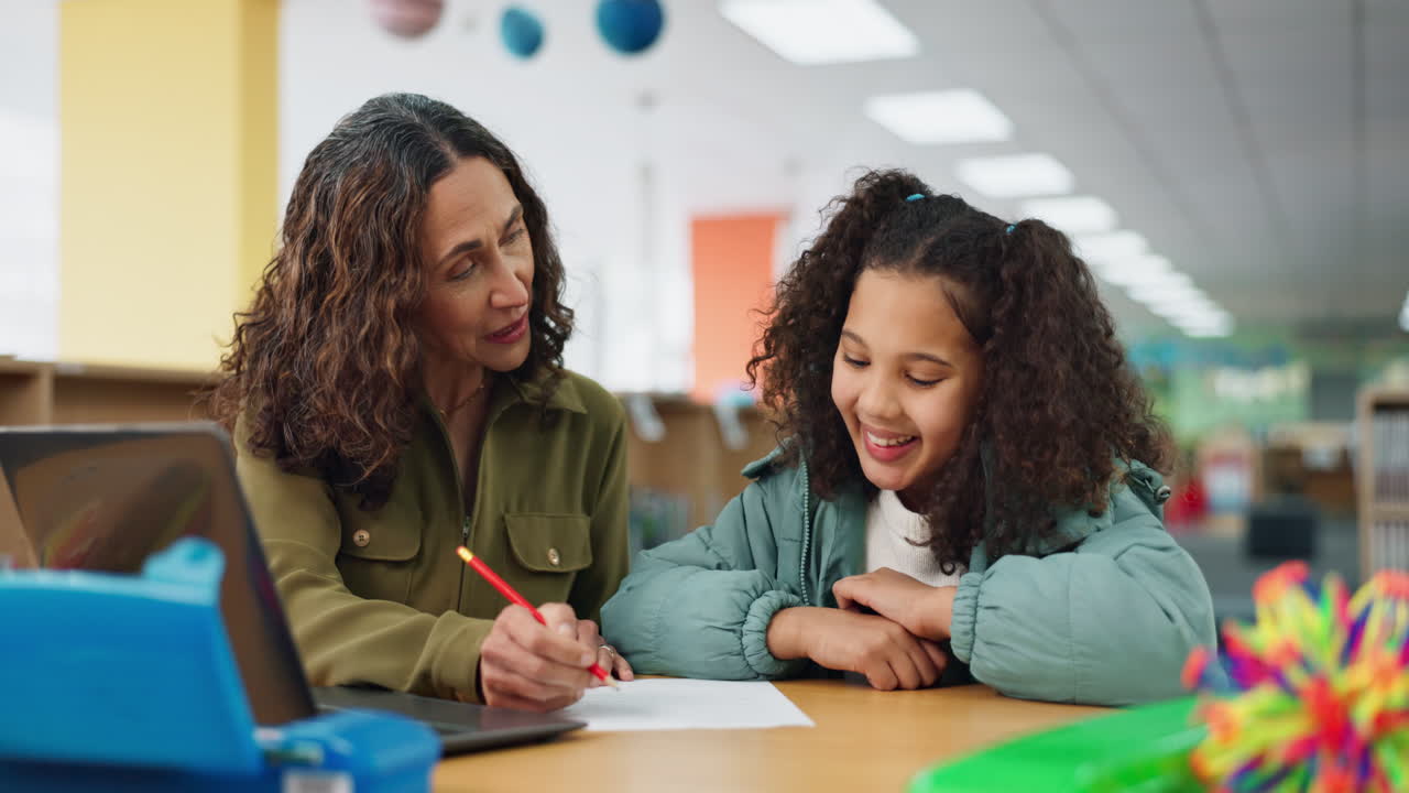 Teacher helping student with schoolwork in library