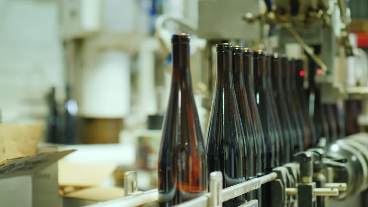 botellas de vino cerradas con un tapón de corcho se mueven a lo largo de la vista de la cinta transportadora desde arriba