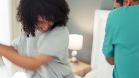 Happy-and-playful-couple-pillow-fighting