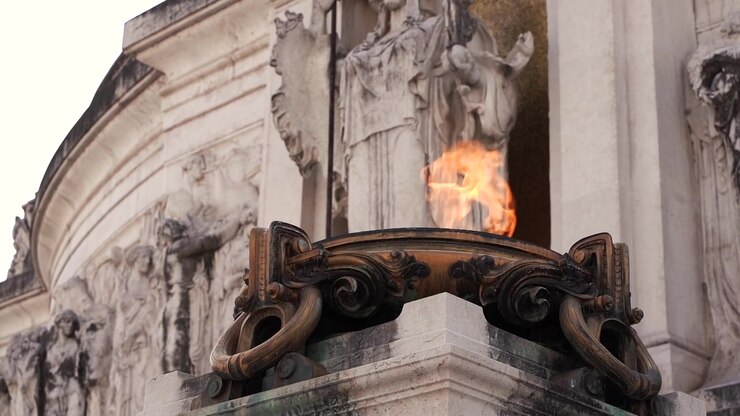 Primo piano di sculture in marmo consumate dal tempo e dettagli architettonici barocchi decorati con un elemento in bronzo alla Fontana di Trevi a Roma, Italia