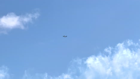 a boeing c-17 globemaster iii flies across a bright blue sky with scattered clouds in geelong, victoria