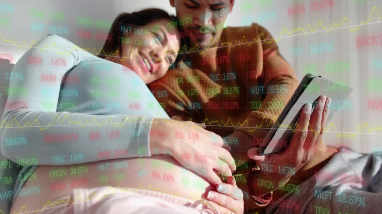Pregnant couple on couch, man tapping tablet, planning baby budget, market tickers overlaying belly
