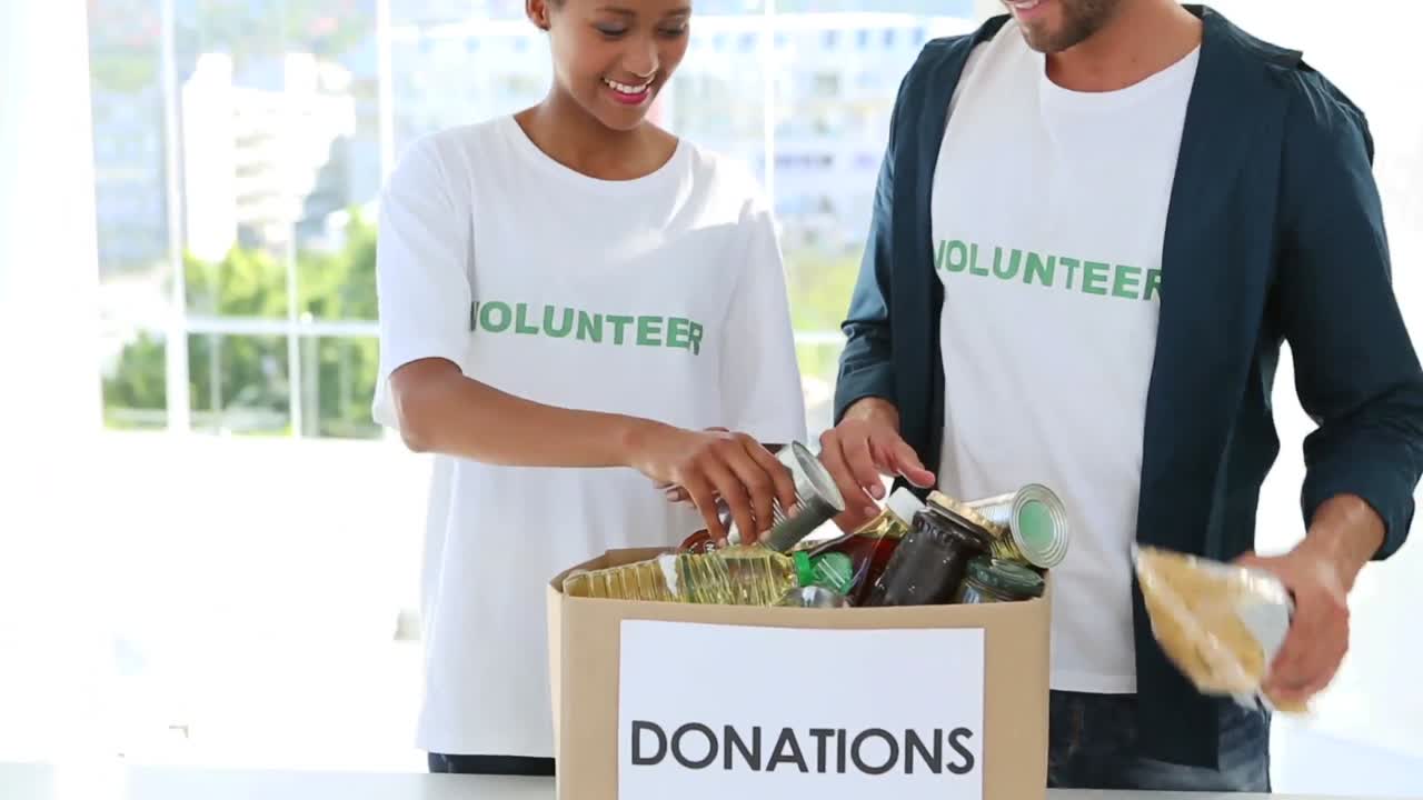 Young volunteer team packing a food donation box